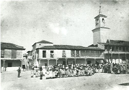 Grupo de escolares en la Plaza. Al fondo, la torre con el reloj antiguo.